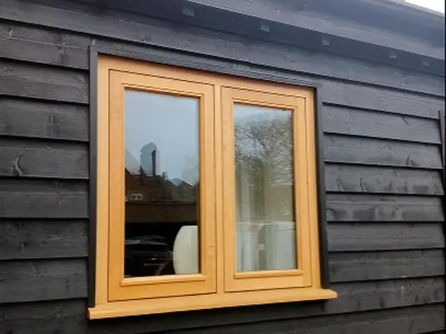 Light oak casement window in black timber cladding